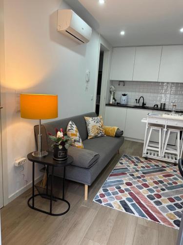 a living room with a couch and a table with a lamp at Francisca River House in Vila Nova de Gaia