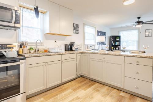 a kitchen with white cabinets and wooden floors at Comfortable 2 Bedroom Near Downtown Atl Sleeps 4 Free Parking in Atlanta