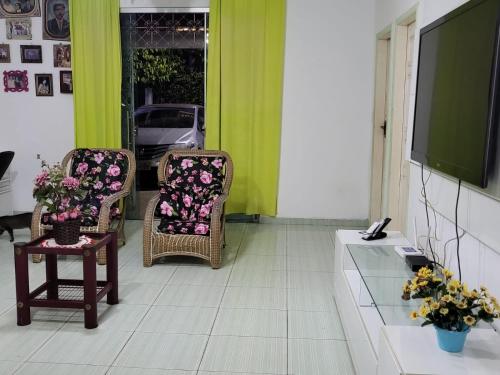 un soggiorno con 2 sedie e una TV di Casa de praia a Belém