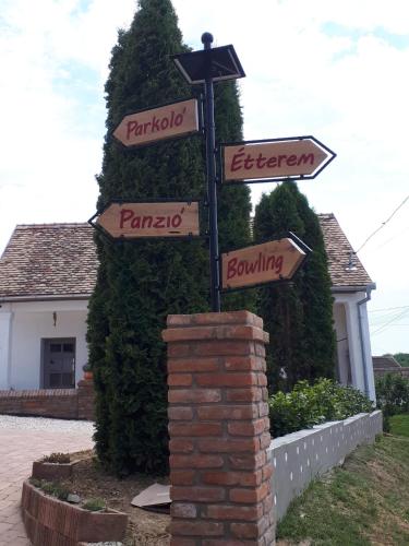 a pole with street signs in front of a house at Beck's Borveranda Palkonya in Palkonya
