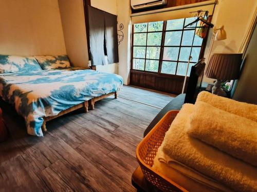 a bedroom with a bed and a couch and a window at Here Sleep Guesthouse in Kaohsiung