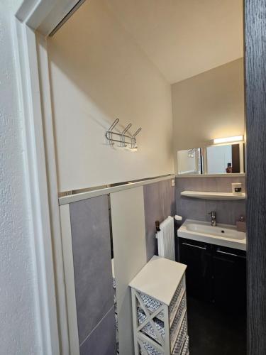 une petite salle de bain avec un lavabo et un miroir dans l'établissement Appartement proche lac de longemer, à La Bresse