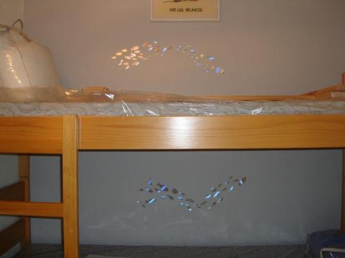 - un lit avec un cadre en bois et un cœur dans l'établissement Studio bord de mer, aux Lecques