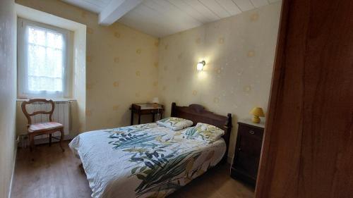 une chambre avec un lit, une chaise et une fenêtre dans l'établissement Maison de famille, à Razecueillé