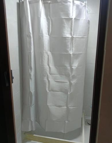 a shower with a white shower curtain in a bathroom at Castle Hotel in Cairo