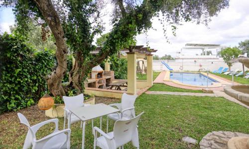 a group of white chairs and a table and a pool at Casa Rural Villa Luna in Barbate