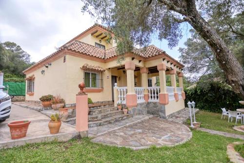 a small yellow house with a tree at Casa Rural Villa Luna in Barbate