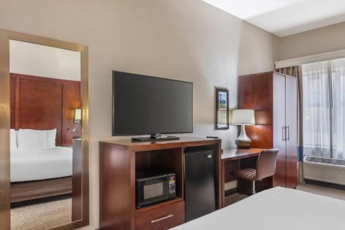 a hotel room with a bed and a flat screen tv at Comfort Inn & Suites Conway in Conway