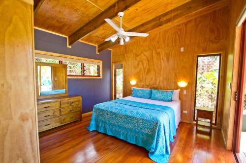 a bedroom with a bed and a ceiling fan at Paradise Holiday Homes Rarotonga in Rarotonga