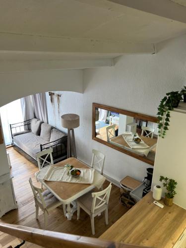 un salon avec une table, des chaises et un canapé dans l'établissement Maisonnette - Résidence Malamousque, à Aigues-Mortes