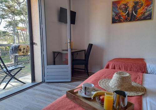 Cette chambre comprend un lit et une table avec un plateau/bouilloire. dans l'établissement Les Jardins de L'Ocean - Climatisé, à Biscarrosse-Plage