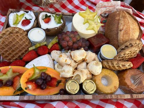 a tray filled with different types of food on a table at Chalé Coimbra in São Bento do Sapucaí