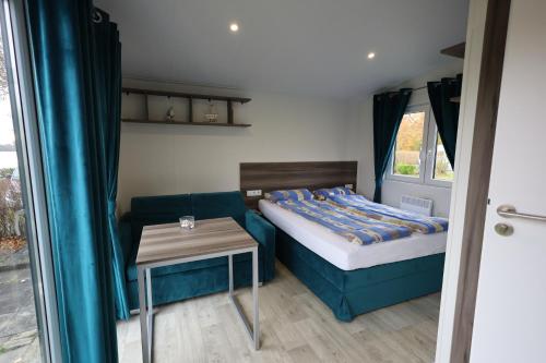 a small room with a bed and a table at Mobilheim Sol in Borgdorf-Seedorf