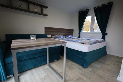 a small room with a bed and a table at Mobilheim Sol in Borgdorf-Seedorf