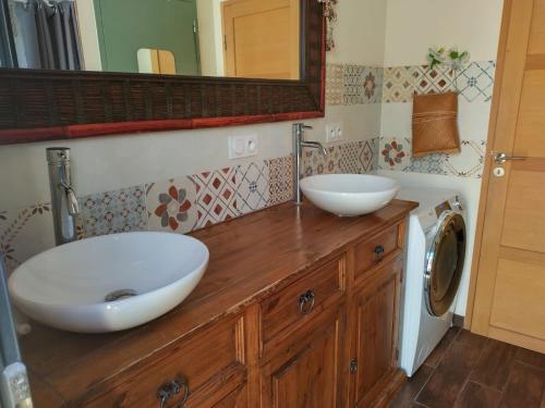 - une salle de bains avec deux lavabos sur un comptoir en bois dans l'établissement Maison calme à 200m de l'océan, à Lacanau