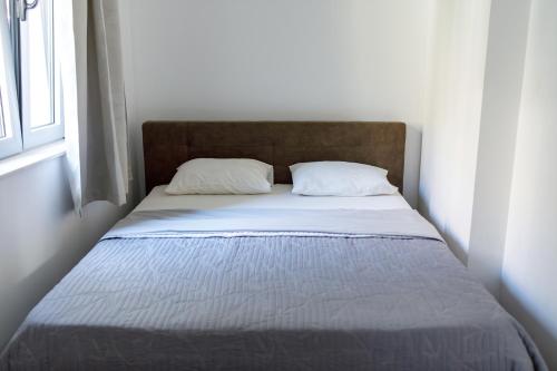 a bed in a white room with two pillows at Apartments Castello Risano in Risan