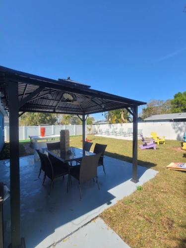 a patio with a table and chairs under a pergola at 2 Mi to Beach Spacious n Relaxin in Largo