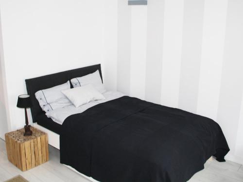 a black and white bed in a white room at Elektoralna Warsaw Apartment in Warsaw