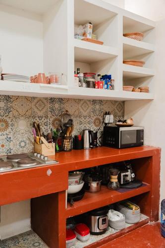 a kitchen with a counter with a microwave at La Casa Mosaica in Campeche