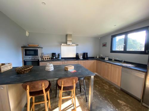 une grande cuisine avec une table et deux chaises dans l'établissement Loregate, à Jullouville