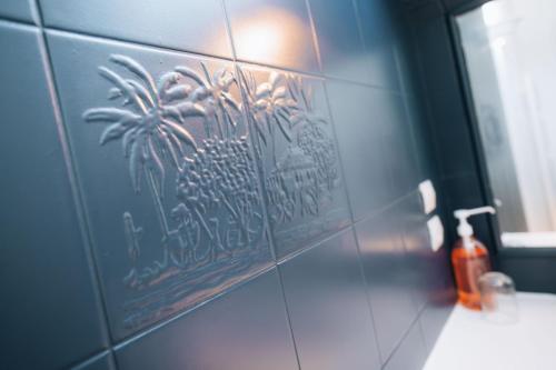 una pared de azulejos con una pintura de palmeras. en Le Perchoir - Duplex - Cozy & Atypical, en Châteauroux