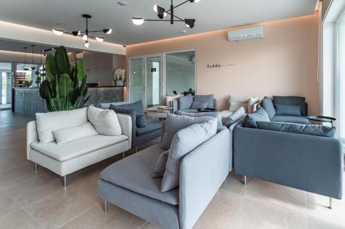 a living room with couches and chairs in a room at Noa Panzio in Vecsés