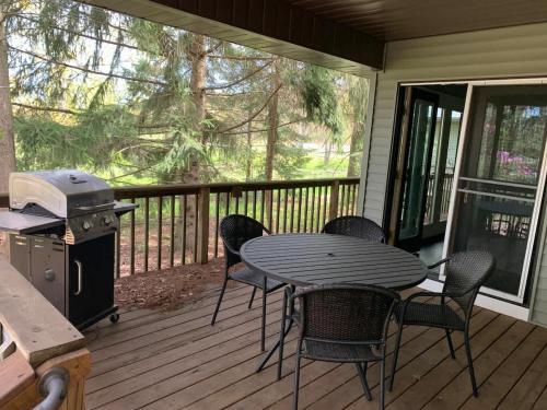 a table and chairs on a deck with a grill at The Sansa Suite at Brants Apple Orchard in Ashtabula