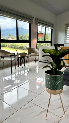 a living room with a potted plant on a tiled floor at Acogedor apartamento con hermosa vista al volcán - The Goat Spot - planta alta in Alto Boquete