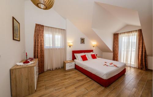 a bedroom with a large bed and two windows at Amazing Home In Kastel Stafilic in Kastel Stafilic