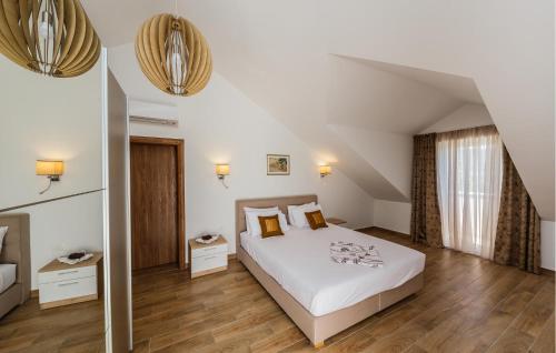 a bedroom with a large white bed and wooden floors at Amazing Home In Kastel Stafilic in Kastel Stafilic