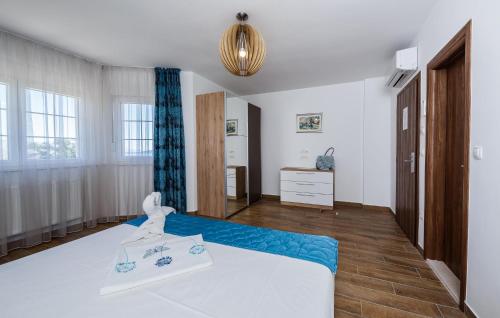 a bedroom with a white bed with a blue blanket at Amazing Home In Kastel Stafilic in Kastel Stafilic