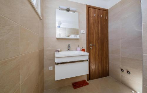 a bathroom with a sink and a mirror at Amazing Home In Kastel Stafilic in Kastel Stafilic