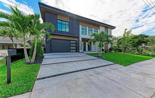 a house with palm trees in front of it at Coastal Luxe, SaltPool Spa, 5miles to Siesta in Sarasota