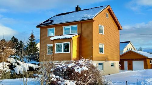 a brown house with snow on the roof at Nonstinden View Lofoten in Ballstad