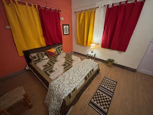 um quarto com cortinas multicoloridas e uma cama em Hoglabon nest em kolkata