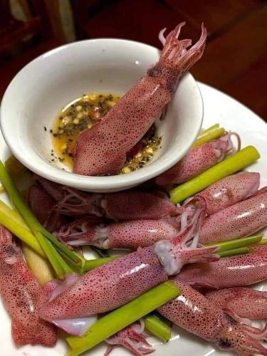 einen Teller Fisch mit einer Schüssel Soße in der Unterkunft Vườn Dừa Cam Bình 1 in La Gi