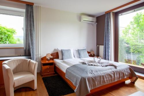 a bedroom with a bed and a chair and a window at Pension Bled in Bled