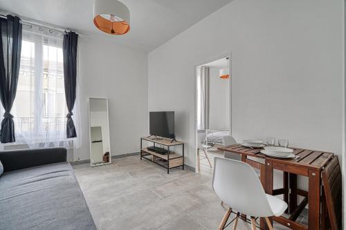 un salon blanc avec une table et un canapé dans l'établissement Appartement fonctionnel & lumineux-Portes de Paris, à Argenteuil