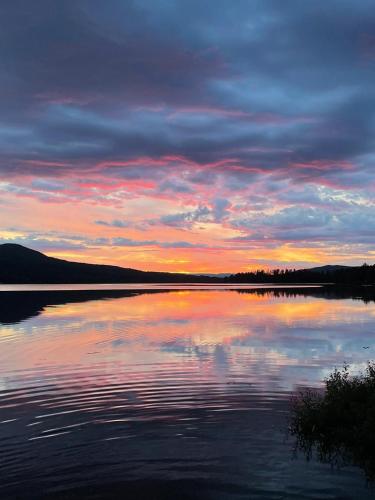 a view of a lake with a sunset in the background at Stuga 5 Varmland in Torsby