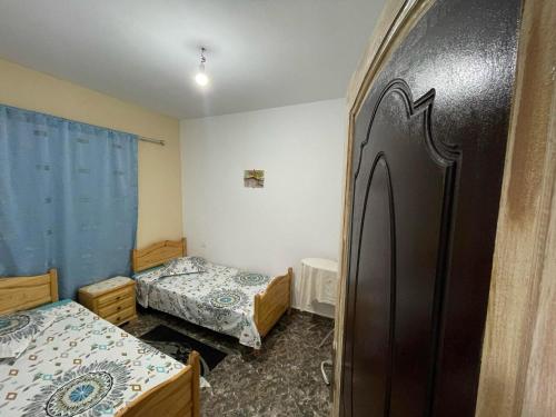 a small room with two beds and a refrigerator at Diar Aquilaria Dar nouha in El Haouaria