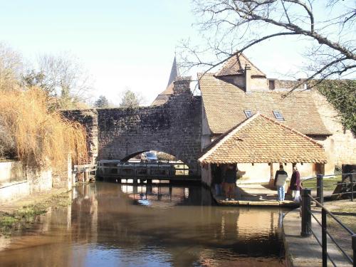 a bridge over a river in front of a building at Aux Vignes in Rott