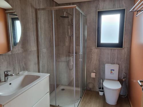a bathroom with a shower and a toilet and a sink at Felicidade in Mondim de Basto