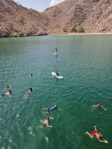 a group of people swimming in a body of water at Camping, Hiking and Dhow Trip- Musandam Uncovered in Dibba