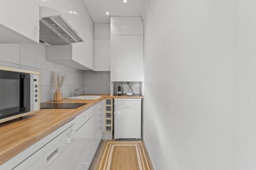 une cuisine avec des armoires blanches et un micro-ondes dans l'établissement Appartement à Cannes, à Cannes