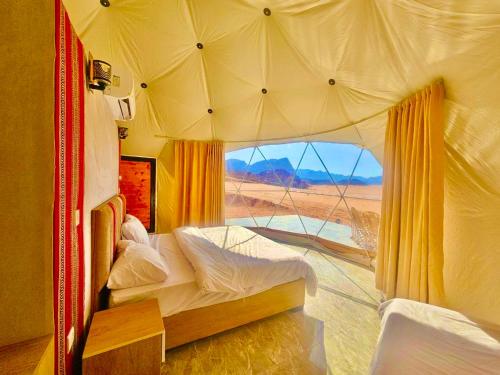 a bedroom with a tent with a view of the desert at NAEL BEDOUIN Camp in Wadi Rum