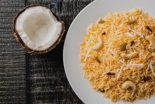 a plate of rice with mushrooms on a table at OAK Edassery's Sealine Villa Stay in Cochin
