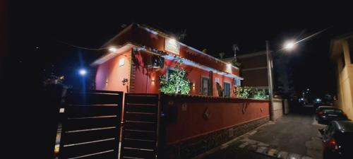 a house with plants on the side of it at night at B&B JOY in Nettuno