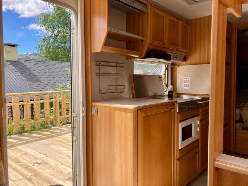 a kitchen with a stove top oven next to a deck at Bed&Breakfast i Campingvogn in Seljord