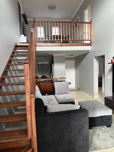 un salon avec un canapé et un escalier dans l'établissement YA Eagle Wings SELF Catering Shared Apartment A, au Cap