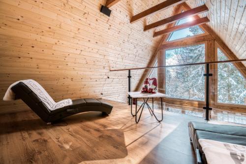 a room with a couch and a chair and a window at Pohorska Gozdna Vila in Pohorje